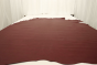 Picture of warm deep red Italian leather for upholstery displayed on a table