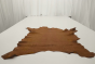 Rich whiskey brown full grain lambskin embossed upholstery leather displayed on a table
