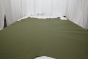 Moss green top grain upholstery leather displayed on a table