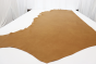 Multi-tone warm gold genuine leather cowhide laying flat on a table