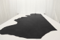Multi-tone smoky black genuine leather cowhide laying flat on a table