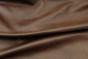 Picture of draping Vintage Redwood, rich brown cowhide leather for upholstery and furniture.