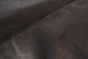 Close up of dark espresso brown distress upholstery leather