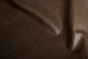 Close up of dark brown with light undertones pull up upholstery leather