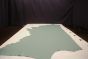 Teal colored leather material laying flat on a table 