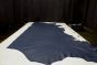 Dark blue colored distress leather cowhide laying flat on a table 