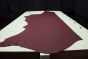 Burgundy genuine leather cowhide laying flat on a table 