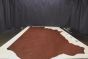 Harness brown colored vintage leather cowhide laying flat on a table 