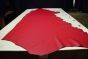 Red colored thick leather cowhide laying flat on a table 