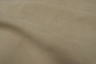 Closeup photo of natural marking on linen-colored nubuck material. 