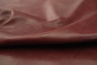 Close up picture of vibrant multitone bordeaux distress leather for upholstery