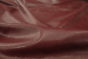 Close up picture of vibrant multitone bordeaux distress leather for upholstery