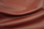 Close up picture of warm deep red Italian upholstery leather