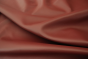 Close up picture of warm deep red Italian upholstery leather