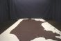 Dark brown colored thick leather cowhide laying flat on a table 