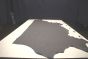 Dark grey colored thick leather cowhide laying flat on a table 