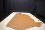 Light brown colored Italian leather cowhide laying flat on a table 