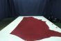 Dark red colored Italian leather cowhide laying flat on a table 
