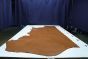 Oak brown colored Italian leather cowhide laying flat on a table 