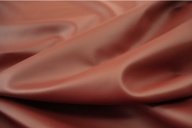 Close up picture of warm deep red Italian upholstery leather