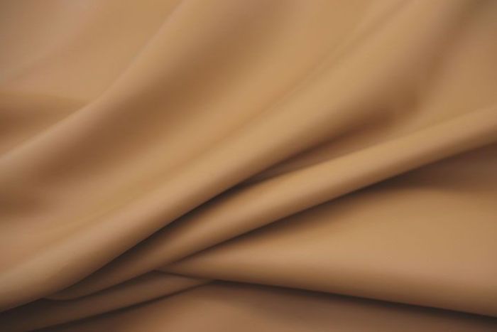 Close up picture of warm golden tan smooth leather for upholstery