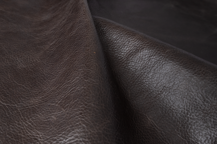 Close up of dark espresso brown distress upholstery leather