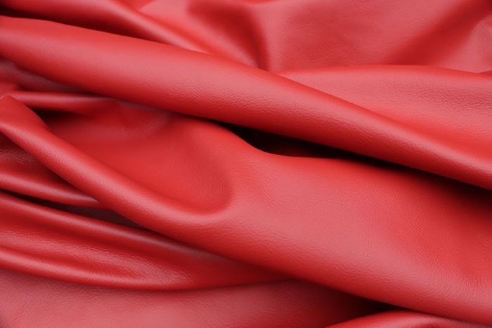 Close up picture of bright red smooth grain leather for upholstery