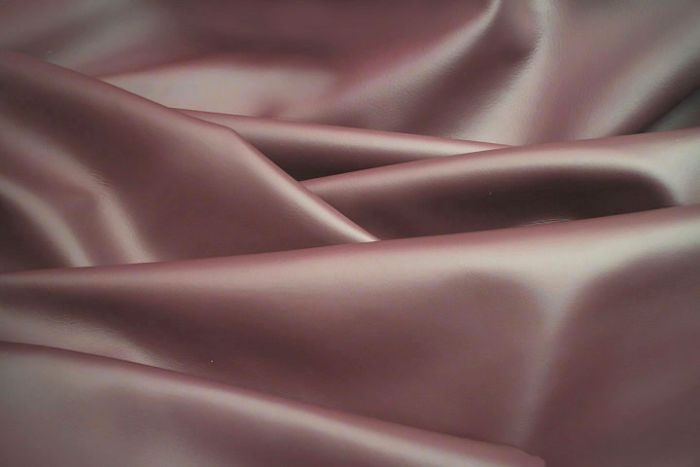 Close up picture of dark purple smooth grain leather for upholstery