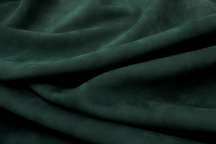 Closeup picture of soft deep green nubuck showing the texture of leather