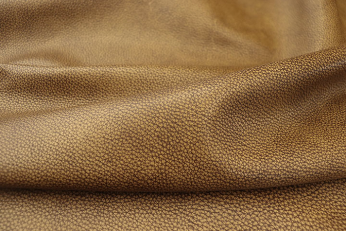 Close up of tan with dark brown highlights pebble grain leather for upholstery