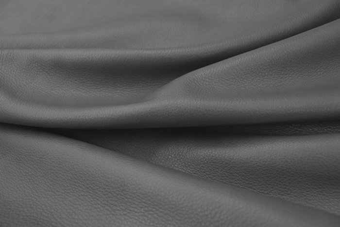 Close up picture of a dark grey with a hint of blue full grain leather for upholstery