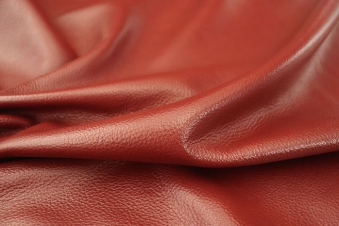 Close up of bright barn red full grain upholstery leather