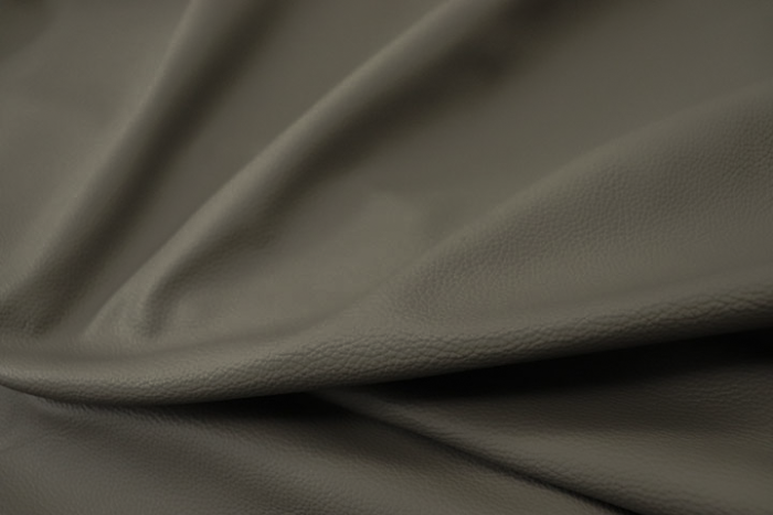 Close up picture of warm dark grey Italian leather for upholstery