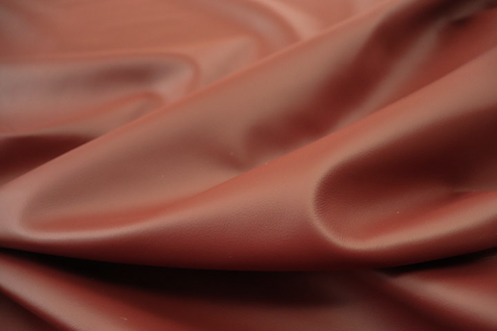 Close up picture of warm deep red Italian upholstery leather