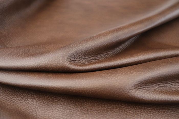 Close up of rich dark brown with red/brown undertones Italian upholstery leather