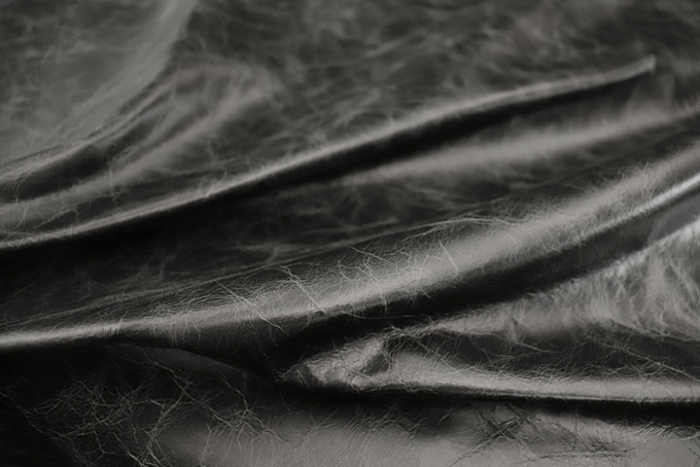 Close up of rich black distress natural grain upholstery leather