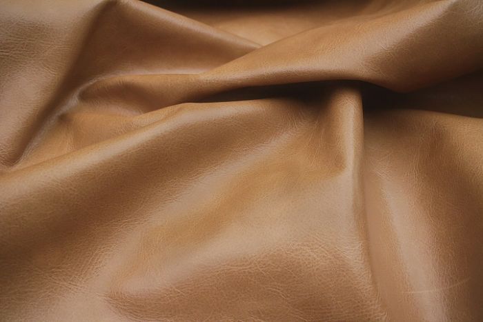 Close up picture of light brown distressed aniline leather for upholstery
