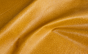 Close up of golden camel color ostrich print embossed upholstery leather