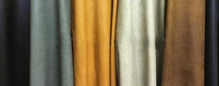  Four upholstery leather hides hanging on a wall 