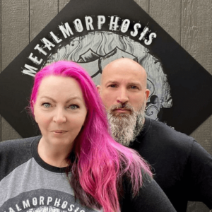 Cat & Rodney in front of a Metalmorphosis sign